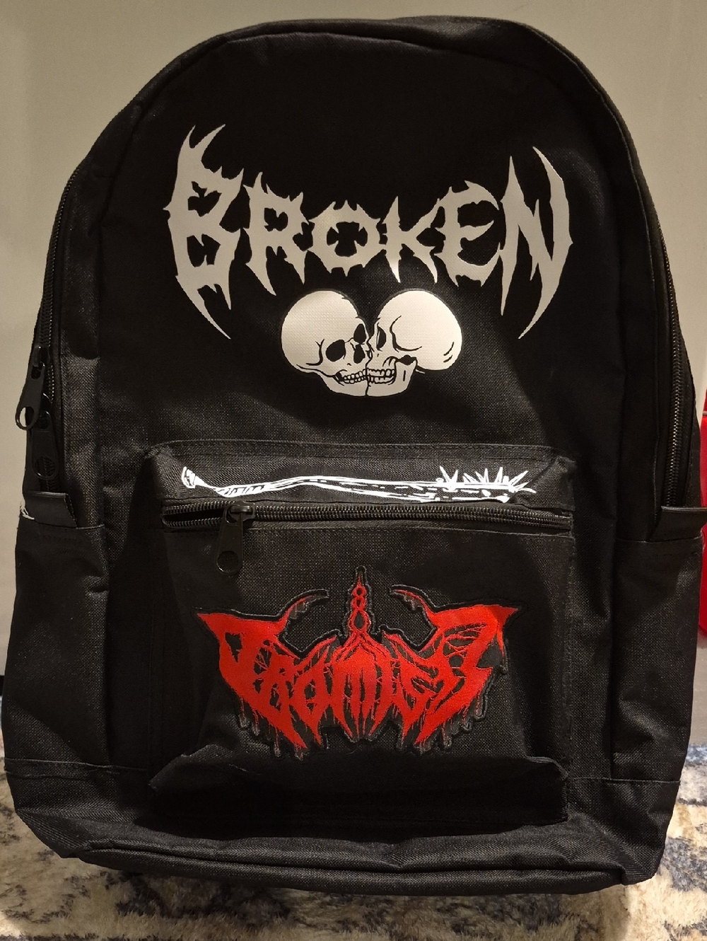 Black Backpack with White Skull Graphic and Red Patch
